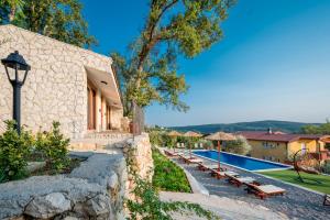 a house with a swimming pool and a stone wall at Case del Tramonto in Kotor