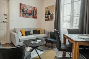 a living room with a couch and a table at Les Lys d'Or Appartement avec Jacuzzi in Saumur +16 photos