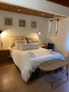 Un dormitorio con una cama grande y una silla. en Casa Alta 8, en San Martín de los Andes