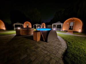 a pool in front of a group of tents at night at Vicolungo Glamour Lodge & SPA - Free SPA Hot Tub e Sauna in Vicolungo