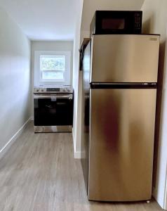 a kitchen with a stainless steel refrigerator and a stove at Chic, Cozy & New Prime location with AC, Street Parking #4 in Renton