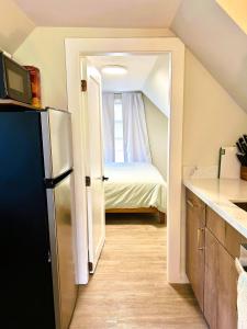 a kitchen with a room with a bed and a refrigerator at Chic, Cozy & New Prime location with AC, Street Parking #4 in Renton