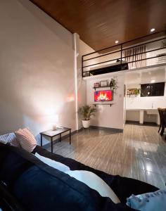 een woonkamer met een bank en een open haard bij Cozy Loft Near the Airport & Beach-Unit I in Puerto Princesa City