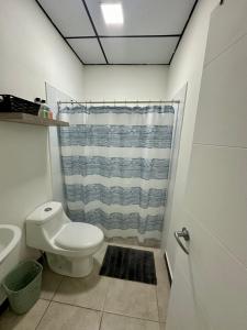 a bathroom with a toilet and a shower curtain at Casa Mia 901SM, habitación 2 in San Miguel