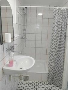 a white bathroom with a sink and a tub at Pokój dwuosobowy Sosnowa in Krasnobród