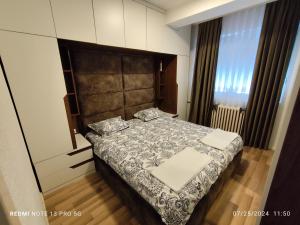 a bedroom with a bed in a room at Green Apartment! in Prishtinë