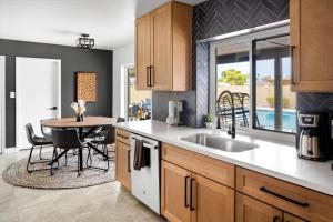 a kitchen with a sink and a table with chairs at Basketball Court Heated Pool Mini Golf & More in Glendale +50 photos