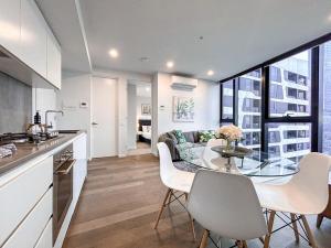 墨尔本Dreamy View On High Level 2br1ba Apt Cbd Poolgy的厨房以及带玻璃桌和椅子的客厅。