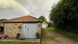 a rainbow over a brick house with a garage at The Smithy in Knaresborough +29 photos