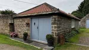 a small brick house with a blue door at The Smithy in Knaresborough