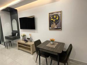 a dining room with a table and chairs and a tv at Crystal Luxury Studio At Kass 1000 in Accra