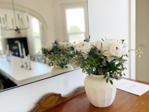 a white vase filled with white flowers sitting on a table at Edna Estate, Sleeps 17, Hot Tub in San Luis Obispo +86 photos