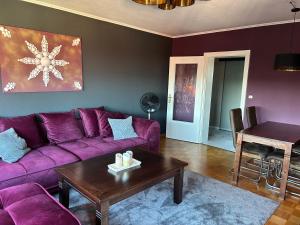 a living room with a purple couch and a table at My sweet Home in Hameln