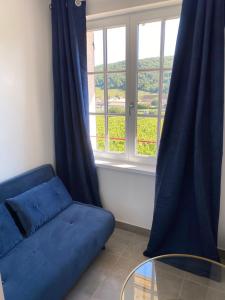 a blue couch in a room with a window at Blue swallow-Fuissé in Fuissé +4 photos