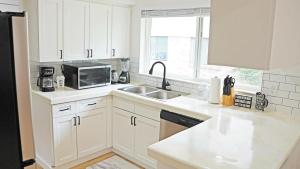 una cucina bianca con un lavello e un forno a microonde di Charming House Central Dallas a Dallas