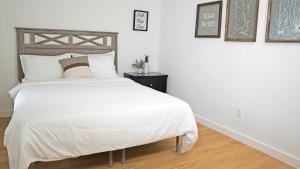 una camera da letto con un letto grande con lenzuola bianche di Charming House Central Dallas a Dallas Altre 15 foto