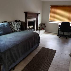 1 dormitorio con 1 cama, 1 silla y chimenea en Cozy home Southside Jax, en Jacksonville