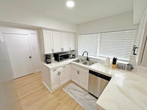 una cucina bianca con un lavello e un forno a microonde di Charming House Central Dallas a Dallas