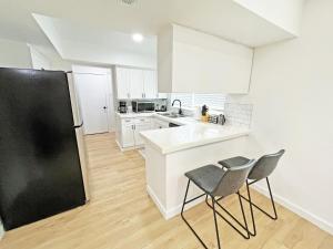 una cucina con mobili bianchi e un frigorifero nero di Charming House Central Dallas a Dallas