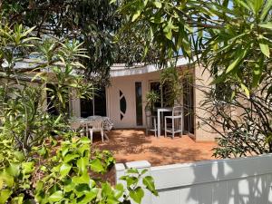 a house with a porch with a table and chairs at Villa front de mer, plage nature in Torreilles