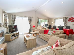 a living room with couches and a tv at 21 Norman Drive Lodge in Great Yarmouth