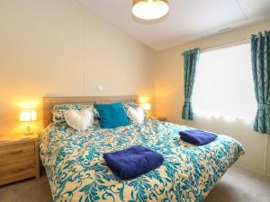 a bedroom with a bed with two blue pillows at 21 Norman Drive Lodge in Great Yarmouth