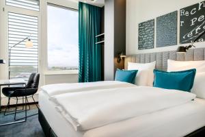 Postel nebo postele na pokoji v ubytování Motel One Karlsruhe