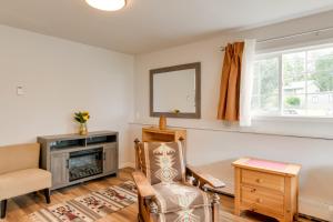 a living room with a fireplace and a chair at 6 Mi to Dtwn Bright and Airy Anchorage Getaway! in Anchorage