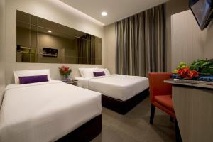 a hotel room with two beds and a television at V Hotel Bencoolen - SG Clean in Singapore
