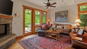 a living room with a couch and a fireplace at Ski in Ski out 4 Bedroom Spruce Peak Lodge Luxury Mountain Cabin By Stowe Mountain Rentals in Stowe