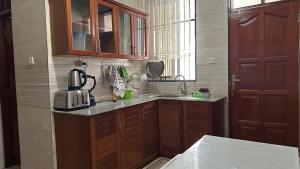 a kitchen with wooden cabinets and a counter top at Homelandheights in Dar es Salaam