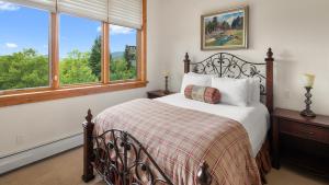 a bedroom with a bed and two windows at Ski in Ski out 4 Bedroom Spruce Peak Lodge Luxury Mountain Cabin By Stowe Mountain Rentals in Stowe +31 photos