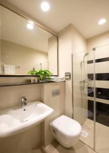 a bathroom with a sink and a toilet and a shower at V Hotel Bencoolen in Singapore
