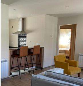 sala de estar con cocina con mesa y sillas en Alvear Suites, en Esquel 2 fotos más