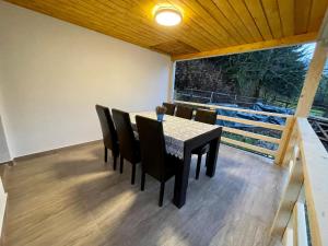 a dining room with a table and chairs and a large window at Căşuţa LA CUCU in Vadu Moţilor +21 photos