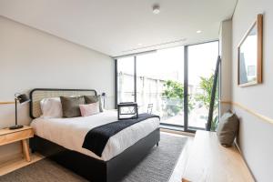 a bedroom with a bed and a large window at ULIV Antara in Mexico City