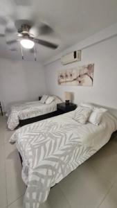 a bedroom with two beds and a ceiling fan at Tranquilidad cerca del mar in Bucerías