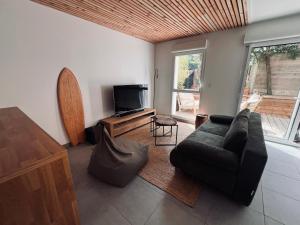 a living room with a couch and a television at Maison à Lacanau Océan in Lacanau-Océan