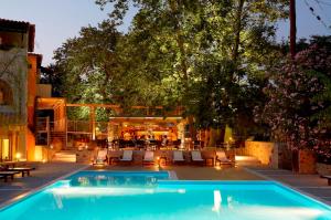 a swimming pool in a yard with chairs and tables at Astoria Hotel in Troulos