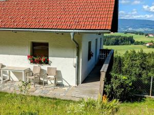 a house with a table and chairs on a porch at Ferienwohnung Waldhauser in Breitenberg