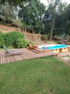 a wooden deck with a swimming pool on top of a yard at Casa da Touça in Celorico de Basto