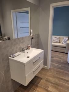 a bathroom with a white sink and a mirror at Apartament Milena in Kruszyn