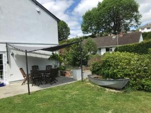 a patio with a table and umbrella in a yard at Bethel Cottage in Lyme Regis