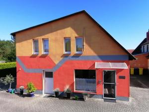 a red and orange house with a black roof at Ferienhaus "Harzblick" in Halberstadt