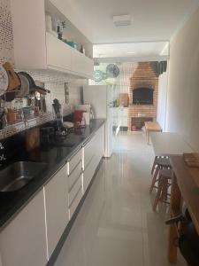 a kitchen with a sink and a table and a fireplace at Casa Águas de Lindoia com acesso ao Thermas in Águas de Lindóia