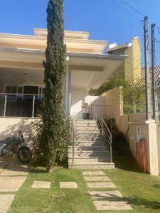 a house with stairs and a tree in the yard at Casa Águas de Lindoia com acesso ao Thermas in Águas de Lindóia