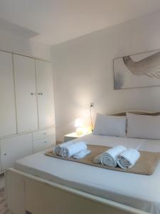 a white bedroom with a bed with towels on it at Oasis Cottage in Krepeni
