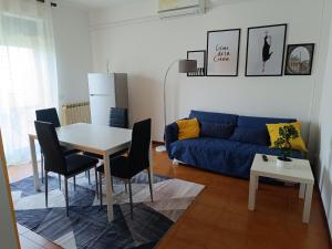 a living room with a blue couch and a table at Appartamento vista mare Vasto Marina in Marina di Montenero