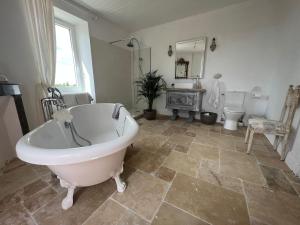 un ampio bagno con vasca e servizi igienici di Bastide Bellevue a Gaudonville