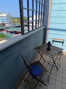 a table and a chair on a balcony with a table and a window at Appartamento vista mare Vasto Marina in Marina di Montenero